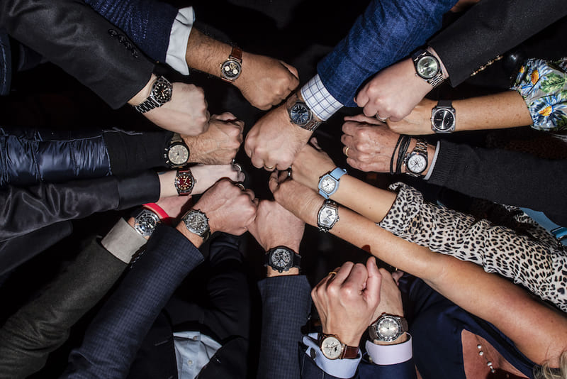 multiple hands fist bumping  wearing different styles of watches unity watch community