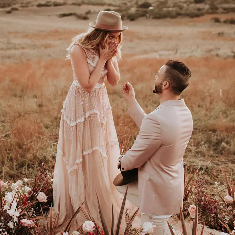 Surprised woman with hands on her face as a man kneels, proposing with a ring in hand. A magical moment of love and commitment.