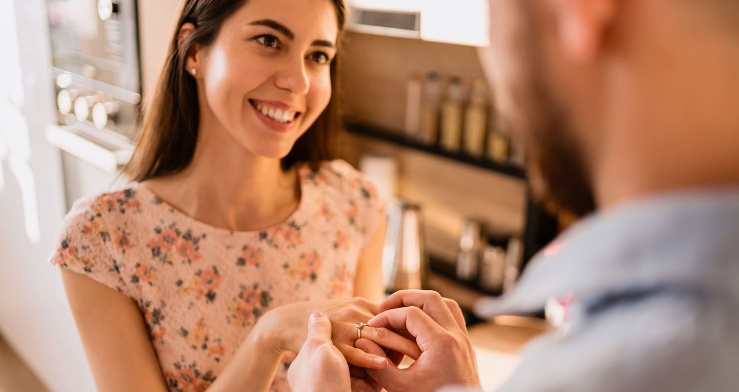 man puts ring on womans finger